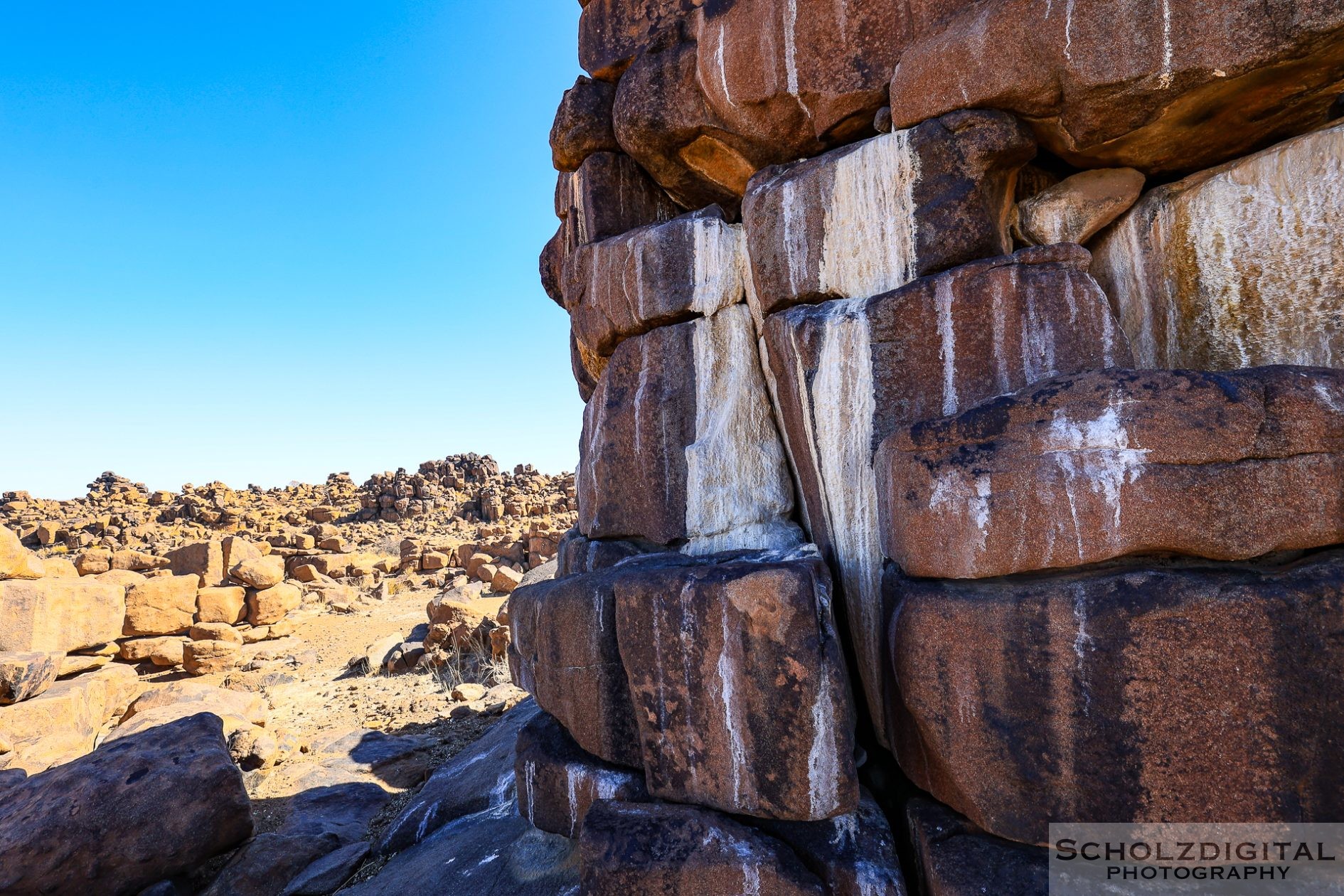 Die senkrechten weißen Streifen auf den Felsen sind Urinspuren der dort lebenden Klippschliefer.