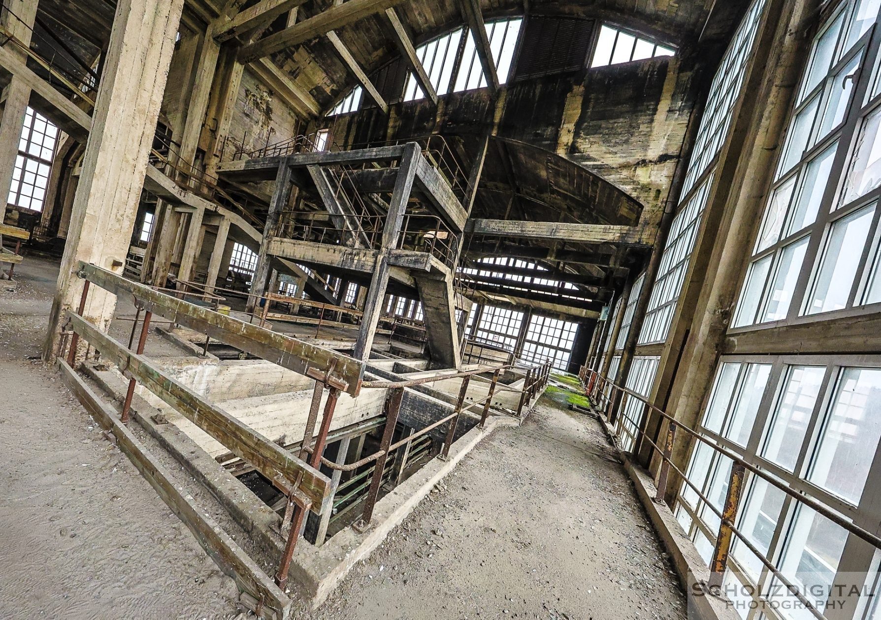 Blick durch eine der großen Hallen mit Stahlträgern und Lichtfall.