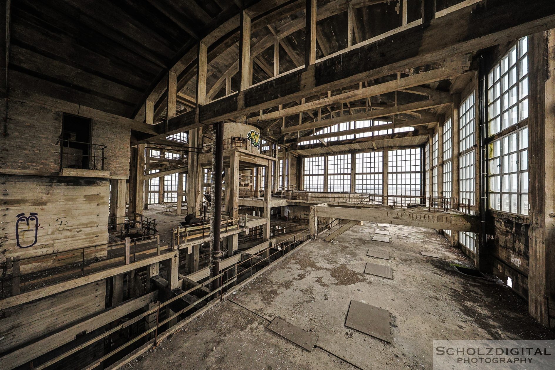 Blick durch eine der großen Hallen mit Stahlträgern und Lichtfall.
